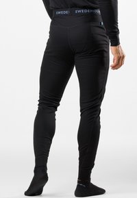 Schwarze gerippte Leggings mit taillierter Passform und einem SWEDEMOUNT-Markenspiegelbund. Das Material hat eine glatte Textur für zusätzlichen Komfort.