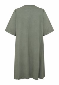 Krátky rukáv, oversize tričko v podobe šiat v tlmenej zelenej farbe, s jednoduchým dizajnom a jemnou textúrou so voľným strihom.