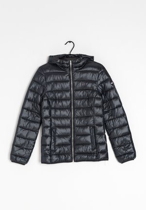 Zwarte doorgestikte jas met capuchon, voorzien van een ritssluiting aan de voorkant en zakken, hangend aan een zwarte hanger tegen een witte achtergrond.