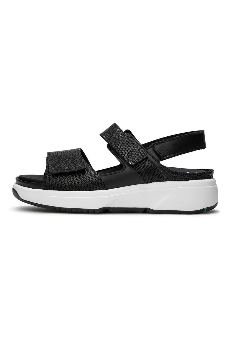 Zwarte sandaal met verstelbare banden, gestructureerde bovenkant en een gevoerde witte zool. Heeft een gesloten achterkant en een rubberen zool voor grip.
