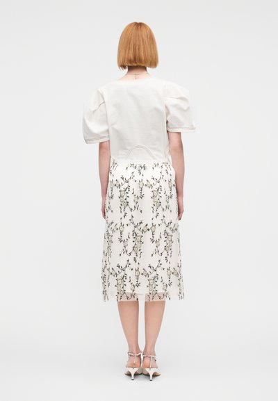 Φόρεμα με κοντά μανίκια, εκρού το πάνω μέρος και φλοράλ φούστα μέχρι τους αστραγάλους. Διαθέτει φουσκωτά μανίκια και εφαρμοστή μέση. Με λεία υφή.