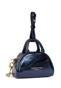 Kleine zwart gepatenteerde leren handtas met gouden hardware, dubbele handgrepen en een afneembare kettingriem; ronde vorm en ritssluiting.