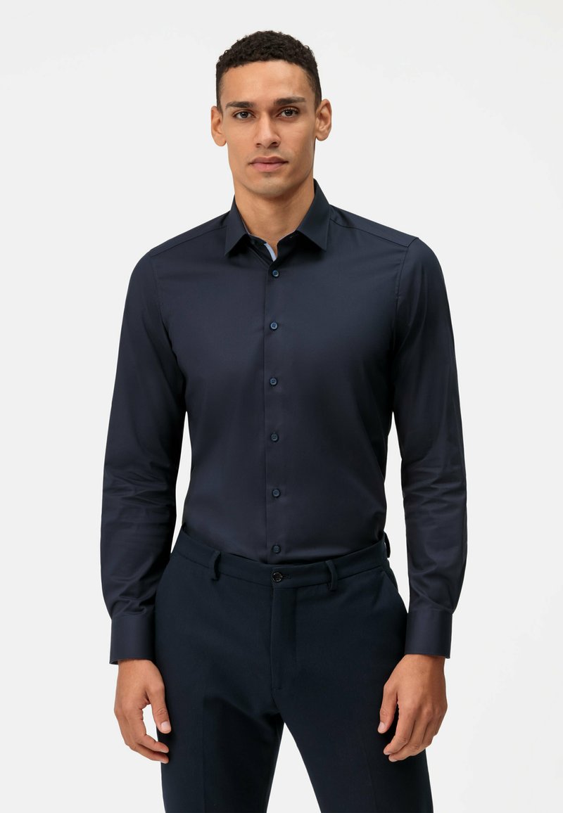 Donkerblauw slim-fit overhemd van gladde stof, met een puntkraag, knoopsluiting aan de voorkant en lange mouwen.