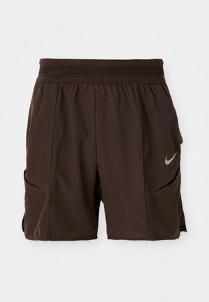 Ciemnobrązowe szorty sportowe z elastycznym pasem, bocznymi kieszeniami i odblaskowym logo Nike na prawej nodze.