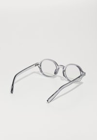 Transparent round-frame glasses with thin arms, featuring clear lenses and a smooth finish. The overall color is light gray.
