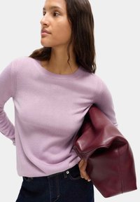 Sweater lavorato a maglia di un leggero lavanda, con scollatura rotonda, bordi a costine e una texture liscia. Abbinato a una borsa in pelle bordeaux profondo.