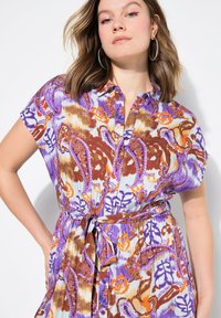 Kurzärmliges Kleid mit einem mehrfarbigen Blumenmuster, das lila, orange und braune Töne zeigt, mit einer Knopfleiste und einem Taillengurt.