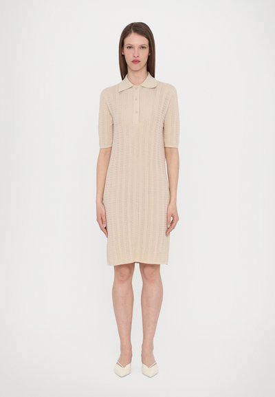 Robe polo beige à manches courtes, avec un motif tricoté texturé, une patte de boutonnage à trois boutons et un ourlet à hauteur de genou.