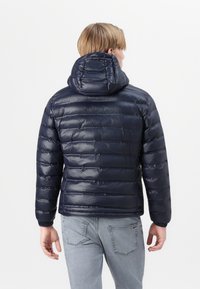 Navy puffer jacket with a hood, featuring quilted panels, glossy finish, elastic cuffs, and a warm, lightweight design.