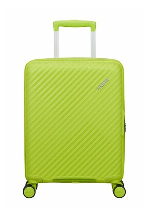 Valigia rigida verde brillante con scanalature diagonali, quattro ruote spinner, manico telescopico e logo "American Tourister".