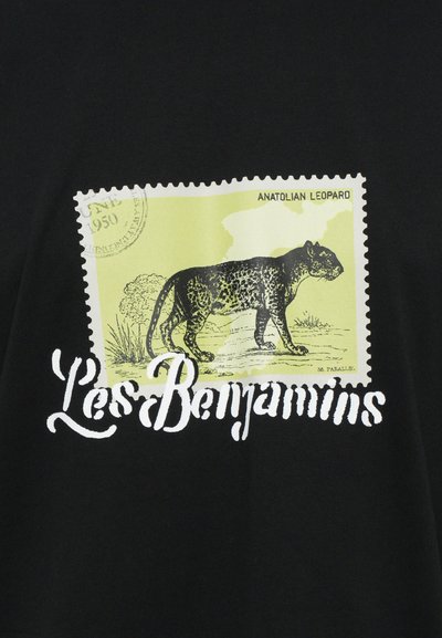 T-shirt noir avec un graphique de timbre représentant un léopard anatolien en vert et noir, avec le texte "Les Benjamins" en blanc en dessous.