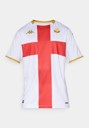 Maillot blanc avec un design de croix rouge. Présente des accents dorés au niveau de l'encolure et des ourlets des manches. Logo Kappa et emblème de lion en doré au-dessus de la poitrine.