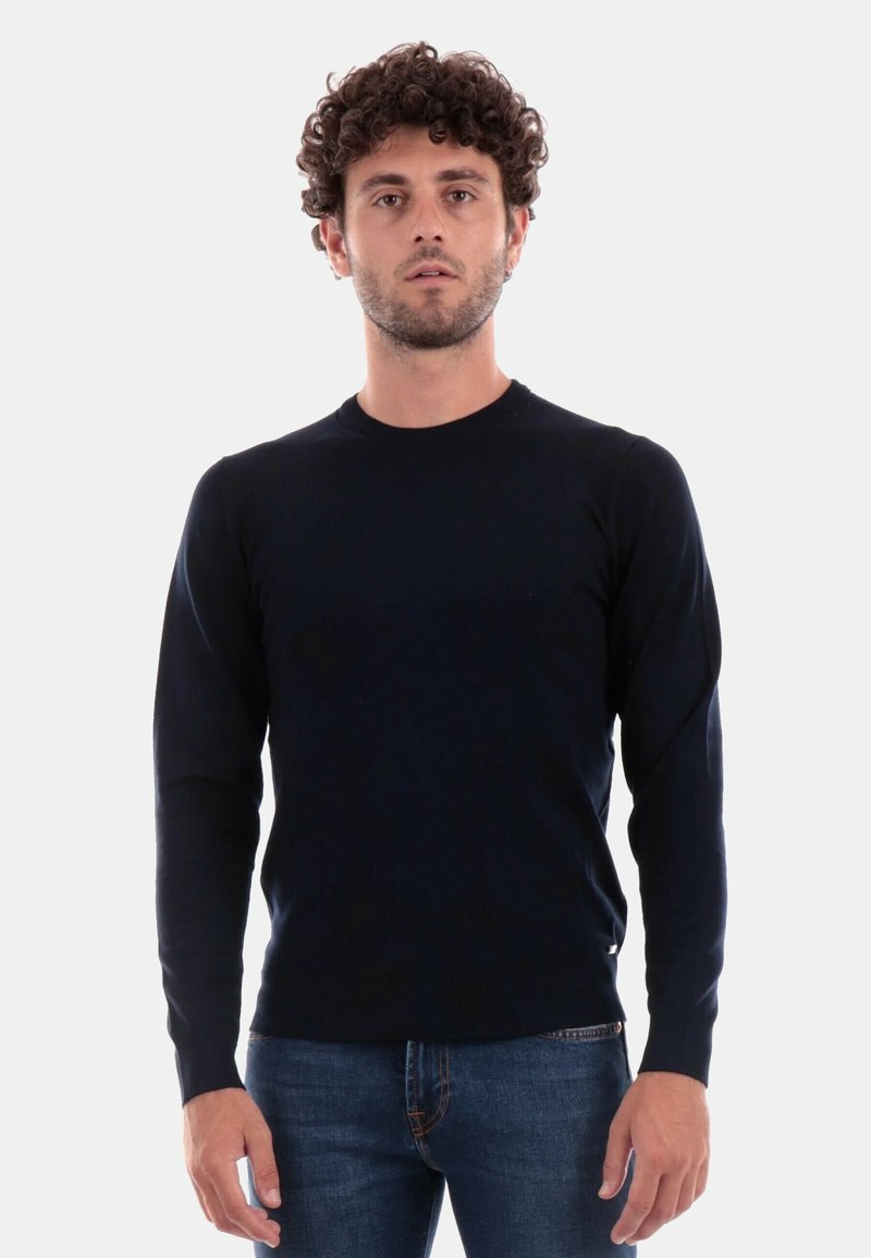 Maglione aderente a maniche lunghe di colore blu navy. Realizzato in un tessuto a maglia liscio, presenta un colletto rotondo e un discreto dettaglio con etichetta sull'orlo.