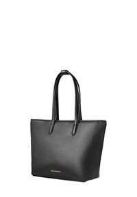 Sac fourre-tout en cuir noir texturé avec deux poignées et petit logo doré près du centre inférieur, debout sur un fond blanc.