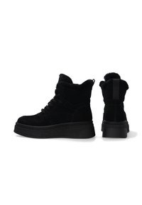 Sorte højhælede sneakers med en overdel i ruskind, tekstureret kilebund, snørebånd foran og detaljer i kunstpels ved kraven. Flad, gummisål for godt greb.