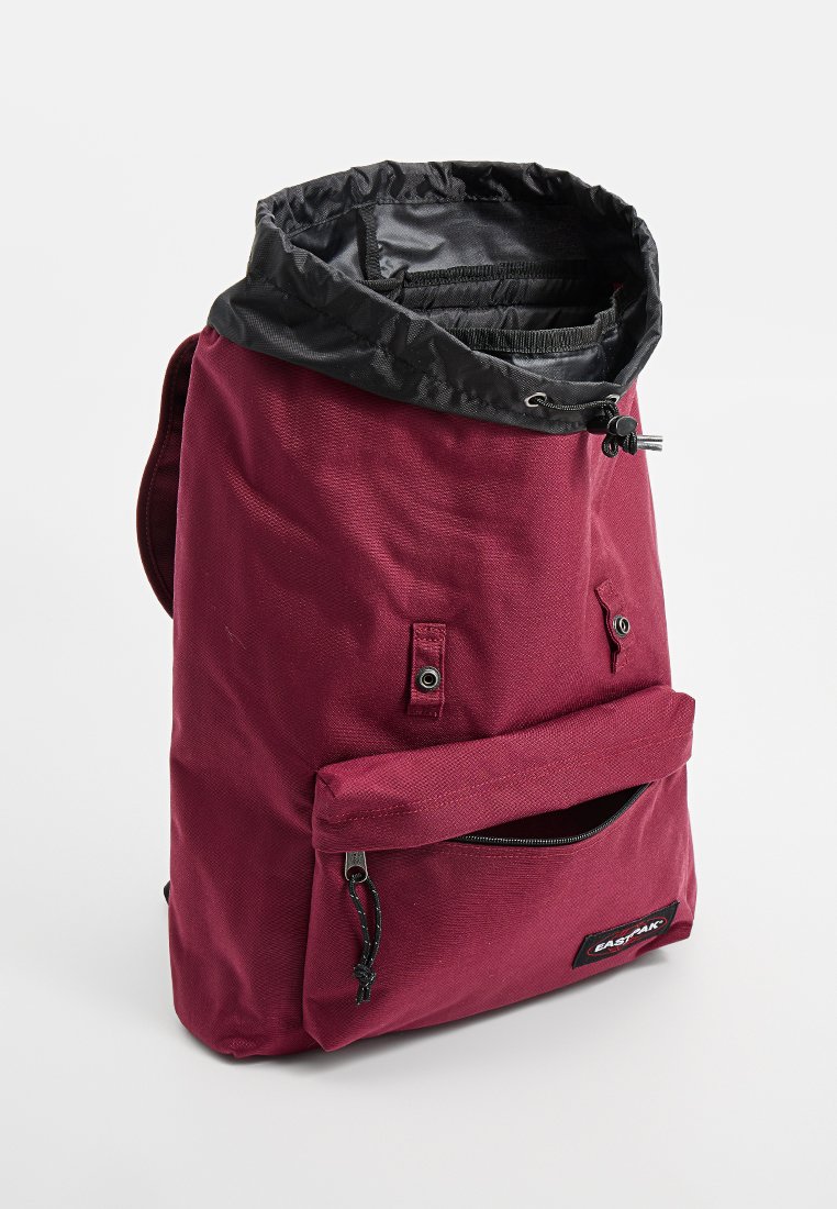 Bordeauxfarbener Rucksack mit schwarzem Kordelzug, strukturiertem Stoff, Front-Reißverschlussfach und zwei Seitentaschen. Mit Branding an der Vorderseite.