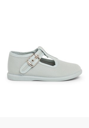 Mocassins Mary Jane en toile gris clair avec un bout arrondi, des découpes sur les côtés et une sangle ajustable avec une boucle en argent. Semelle en caoutchouc.