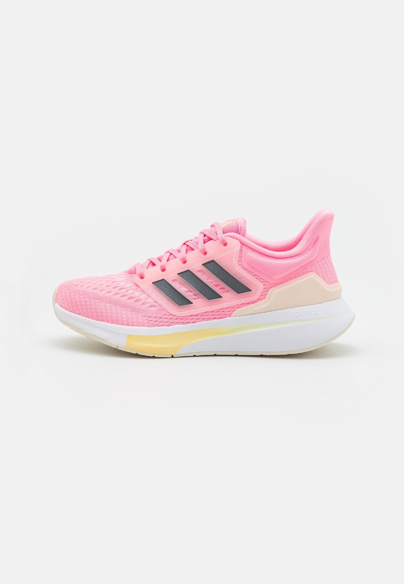 Juoksukengät, joissa on vaaleanpunainen verkko-osa, mustat raidat, valkoinen välipohja ja keltaisia yksityiskohtia. Varustettu tekstuuripinnalla ja pehmustetulla nilkkaremmillä.