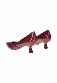 Décolleté in pelle verniciata borgogna con punta arrotondata, dettaglio arricciato sul davanti e tacco corto e inclinato. Base nera in accentuazione sul tacco.