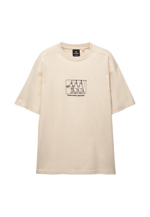 T-shirt en coton beige à manches courtes, à coupe décontractée, présentant une illustration noire imprimée et le texte : "Il y a toujours un bon endroit."