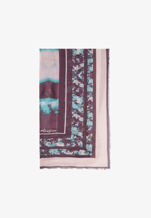 Rektangulært tørklæde med lilla, turkis og hvide blomsterprint, markerede striber og teksten „#livefree“ i det ene hjørne.