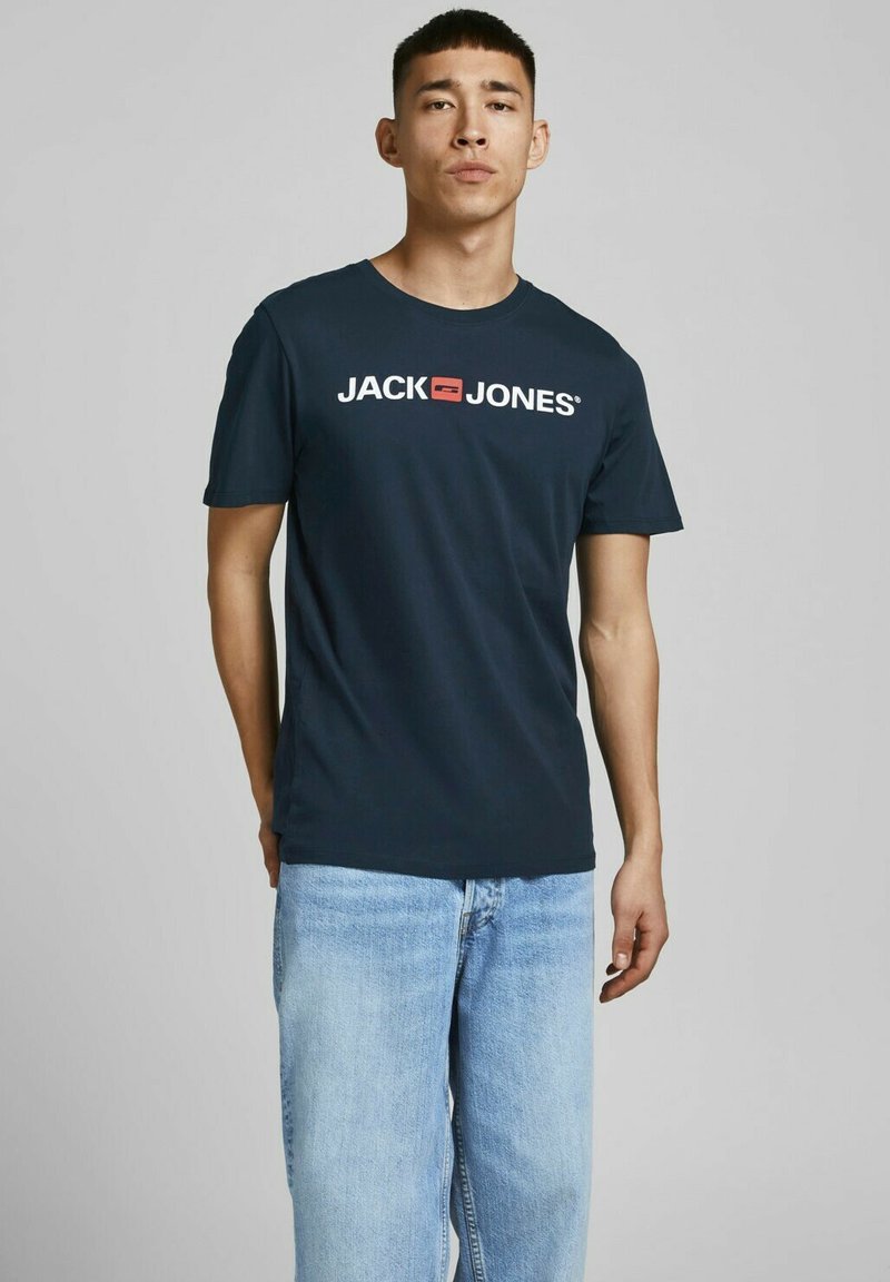 Navyblaues T-Shirt mit kurzen Ärmeln aus Baumwolle. Mit einem weißen Logo-Druck "JACK & JONES" über der Brust. Gerade geschnitten mit Rundhalsausschnitt.