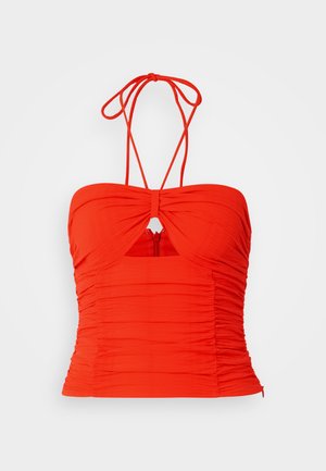 Rode getailleerde haltertop met geplooide textuur, een sleutelgatdetail in het midden en verstelbare strikken. Ritsluiting aan de achterkant.