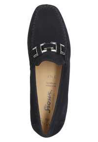 Marineblauer Wildleder-Mokassin mit silberner Schnallenverzierung, gesticktem Rand, weichem Innenleben und runder Zehenform. Markenname auf der Innensohle sichtbar.