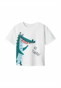 Camiseta de algodón blanca con un gráfico de cocodrilo de dibujos animados en verde y azul, con el texto "¡HOLA!" en negro. Con mangas cortas y cuello redondo.