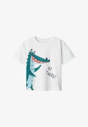 Bijela pamučna majica s kratkim rukavima koja prikazuje karikaturu krokodila u zelenoj i plavoj boji, s natpisom "ZDRAVO!" u crnoj boji. Okrugli izrez.