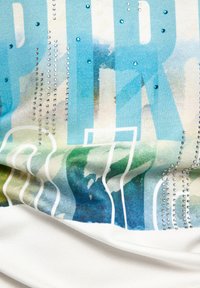 Grafik-T-Shirt mit einem Aquarellmuster in Blau- und Grüntönen, verziert mit Strasssteinen und großem Text in kontrastierenden Farben.