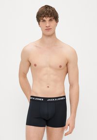 Sorte boxer shorts med en tætsiddende design, elastisk talje med "JACK & JONES" i hvid tekst; glat stofstruktur.