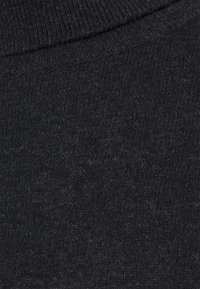 Svart stickad tyg med en mjuk textur, med en närbild av vävmönster och en hög krage.