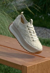 Λευκό υφασμάτινο sneaker με σχέδιο κορδονιού, ενισχυμένη φτέρνα και αυλακωτή σόλα. Διαθέτει μαλακό πάτο και διακριτό λογότυπο στην γλώσσα.