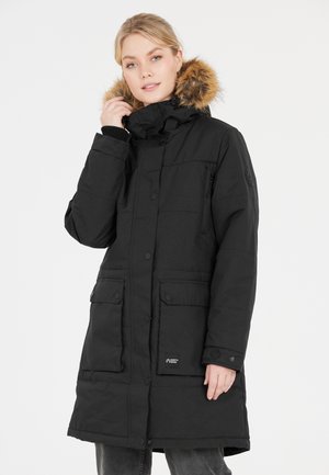 Sort polstret parka med pelsbesat hætte, trykknapper, sidelommer og ribbede manchetter. Har et logo på frontlommen.