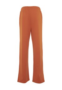 Pantaloni arancioni, svasati e morbidi. Realizzati in tessuto soffice, con una cintura elastica per il massimo comfort. Senza motivi visibili.