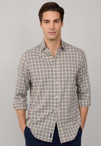 Camisa de hombre de manga larga en color beige, azul marino y blanca con estampado de cuadros, cuello abotonado, puños enrollados y diseño ajustado. Material de algodón.