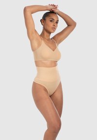 Beige bh met verstelbare bandjes en gladde, rekbare stof, gecombineerd met een hooggelegen beige slip met een gestructureerd ontwerp.
