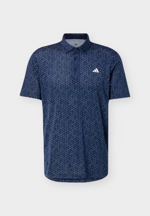 Laivastonsininen, lyhythihainen poolopaita, jossa pieni valkoinen geometrinen kuvio ja valkoinen Adidas-logo vasemmassa rinnassa.