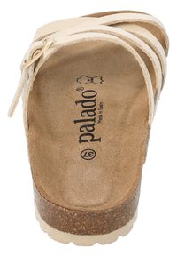 Sandal in pelle beige con tre fascette, suola in sughero e soletta imbottita. Presenta il logo stampato sulla soletta, design piatto e minimalismo nei dettagli.