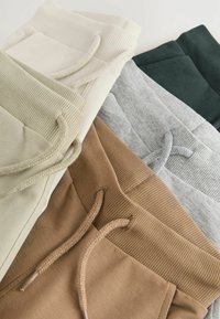 Ensemble de pantalons de survêtement en beige, olive, gris, marron et vert foncé. Comprend des ceintures côtelées, des cordons de serrage et des poches latérales.