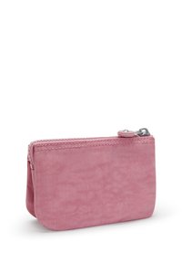 Roze stoffen zakje met een gladde textuur, ritssluiting en gestikte accenten. Compact ontwerp met een afgevlakte onderkant voor gebruiksgemak.