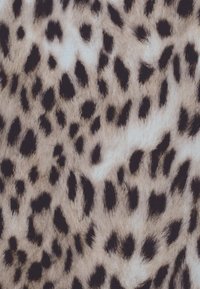Beige a světle hnědá tkanina s nepravidelnými černými skvrnami leopardího vzoru, která vytváří strukturovaný zvířecí vzor.