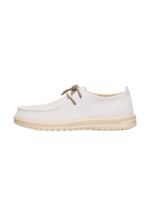 White suede shoes with a rounded toe, beige rubber sole, and two brown laces. Features stitching details along the edges.