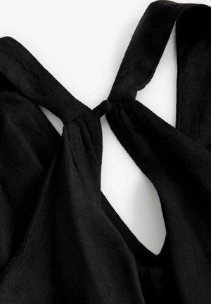 Top en tissu noir avec un design noué à l'arrière, offrant une texture douce et une apparence légère.