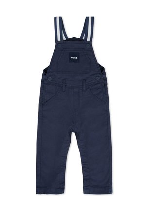 Salopette en coton bleu marine avec bretelles rayées réglables, cinq poches, fermetures à boutons et un écusson logo sur le bavoir.