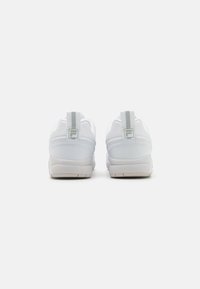 Baskets blanches en cuir lisse avec un col rembourré et une semelle en caoutchouc texturé. Comprend un talon renforcé et un logo au dos.