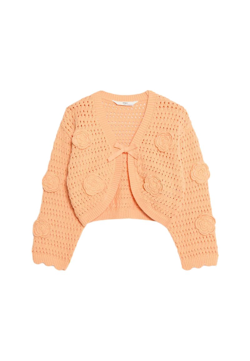 Cardigan court en tricot ouvert de couleur pêche douce avec des appliqués de fleurs arrondies sur les manches et un détail central en nœud. Texture en tricot et manches courtes.