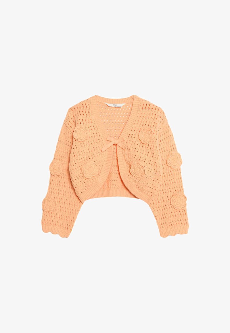 Zkrácený kardigan s otevřeným pletením v jemné broskvové barvě, zdobený kulatými aplikacemi květin na rukávech a středovým detailem ve tvaru mašle. Pletená textura a krátké rukávy.