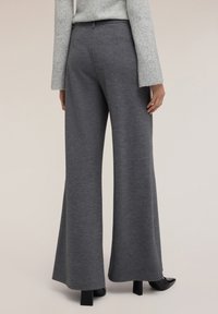 Pantaloni grigi a gamba larga realizzati in tessuto morbido, caratterizzati da una superficie liscia e una vestibilità sartoriale, con una vita pulita e un'orlo svasato.